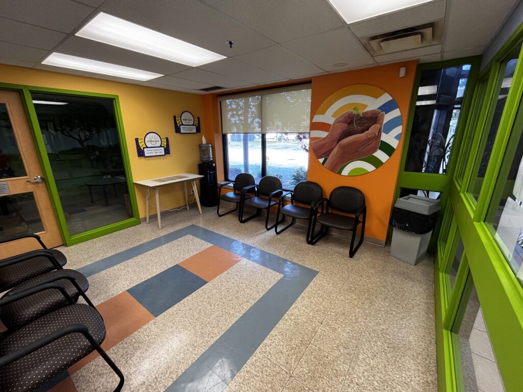 An indoor waiting area with colorful walls featuring a vibrant mural.